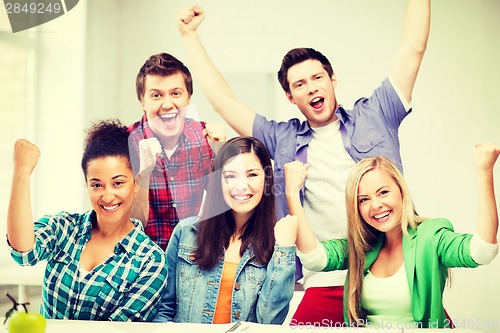 Image of students holding hands up at school