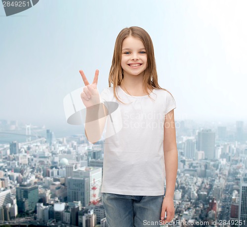 Image of little girl in white t-shirt showing peace gesture