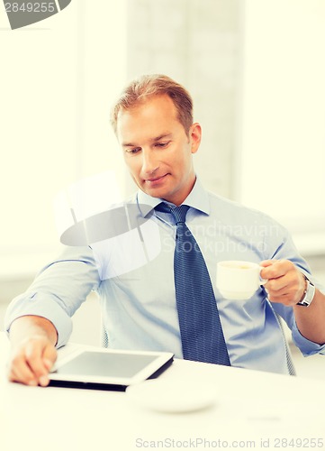 Image of businessman with tablet pc and coffee in office