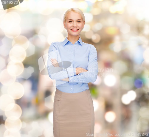 Image of young smiling businesswoman with crossed arms