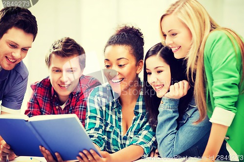 Image of students reading book at school