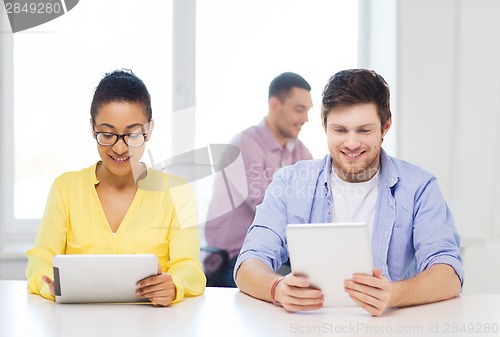 Image of smiling team with tablet pc computers at office