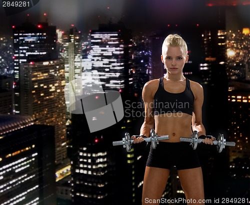 Image of sporty woman with heavy steel dumbbells