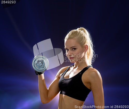 Image of young sporty woman with heavy steel dumbbell