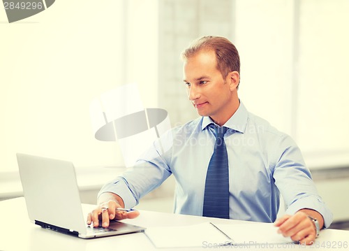 Image of miling businessman working in office