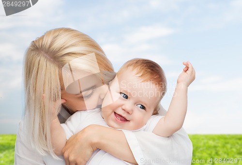 Image of happy mother kissing smiling baby