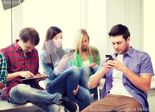 Image of students looking into devices at school