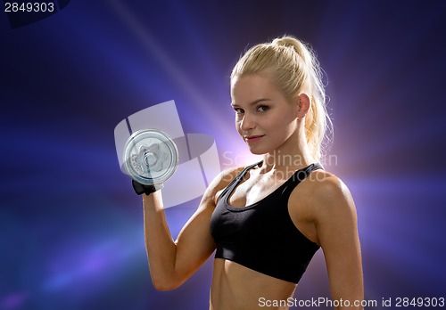 Image of young sporty woman with heavy steel dumbbell