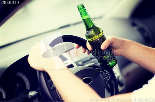 Image of man drinking alcohol while driving the car