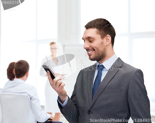 Image of young smiling businessman with smartphone