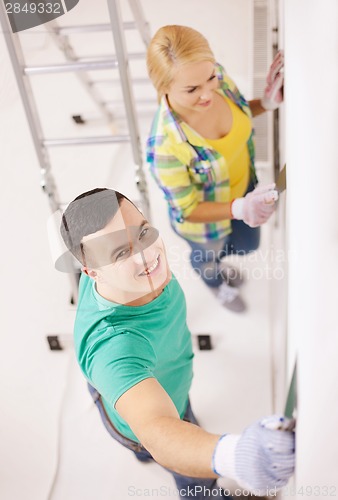 Image of smiling couple doing renovations at home