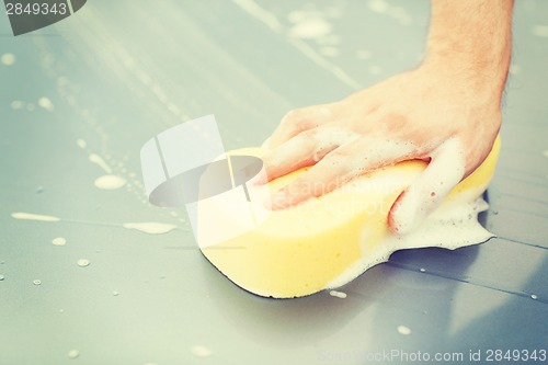 Image of man washing a car