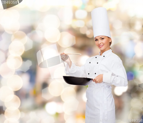 Image of smiling female chef with pan and spoon