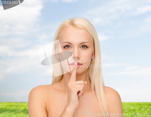 Image of calm young woman with finger on lips