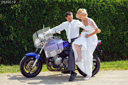 Image of beautiful young wedding couple on motorcycle