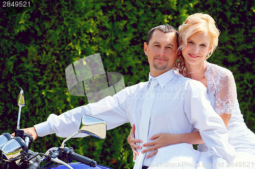 Image of beautiful young wedding couple on motorcycle