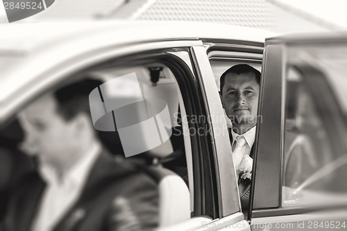 Image of groom sitting in a car