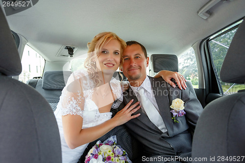 Image of beautiful young wedding couple in car