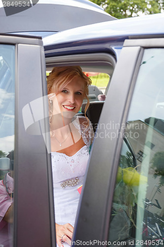 Image of attractive caucasian bride sitting in car