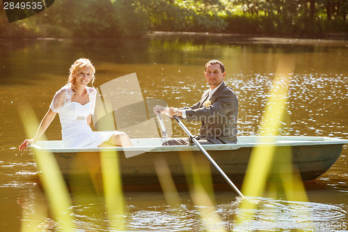 Image of Young just married bride and groom on boat