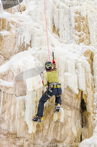 Image of Young man climbing the ice