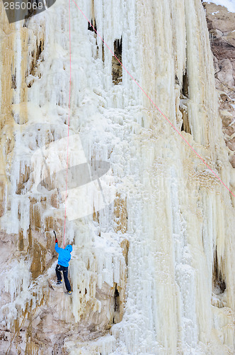 Image of Young man climbing the ice