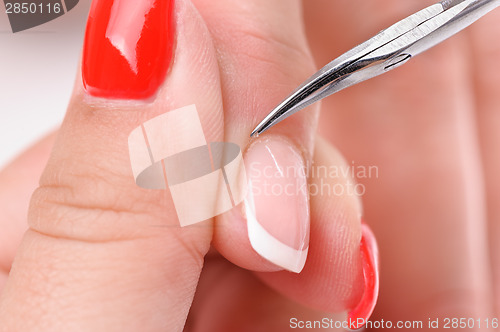 Image of manicure applying - cutting the cuticle 