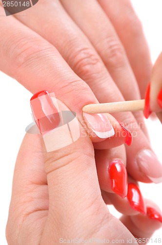 Image of manicure applying - cleaning the cuticles 