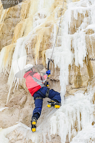 Image of Young man climbing the ice