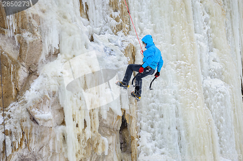 Image of Young man climbing the ice