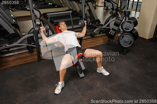 Image of Young man doing Dumbbell Incline Bench Press workout in gym