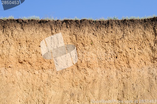 Image of Cut of soil with different layers, grass and sky