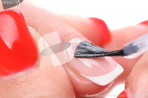 Image of manicure, applying clear enamel