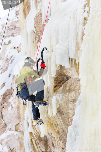 Image of Young man climbing the ice