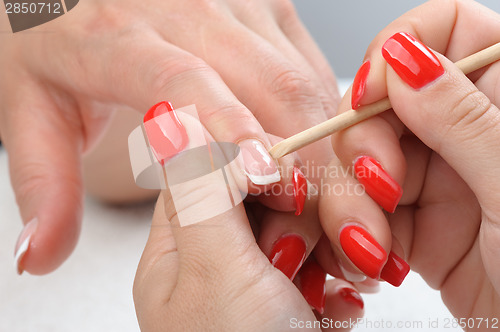 Image of manicure applying - cleaning the cuticles 