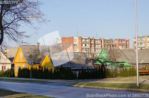 Image of rural wooden house and multistorey red brick house 