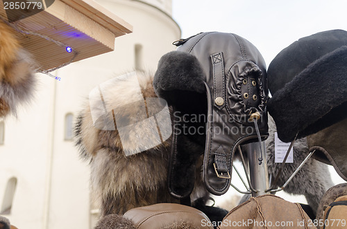 Image of black leather beautifully sewn hats in market 