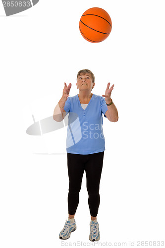 Image of Senior woman throwing basketball