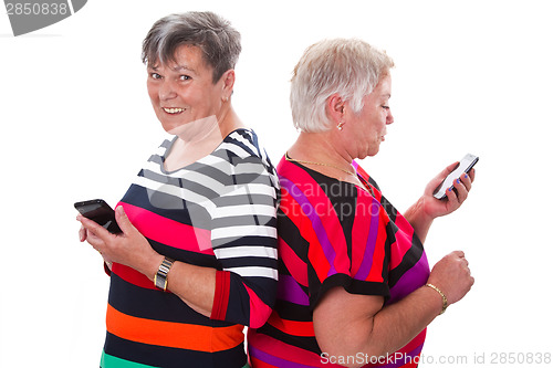 Image of Two senior women communicating with cellphones