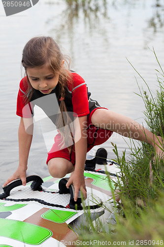 Image of Little girl and windsurfing board