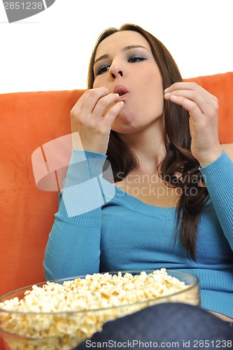 Image of young woman eat popcorn and watching tv