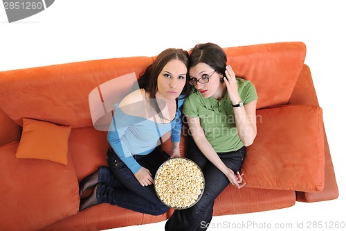 Image of female friends eating popcorn and watching tv at home