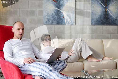 Image of young couple using Laptop computer at home