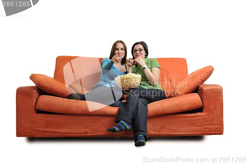 Image of female friends eating popcorn and watching tv at home