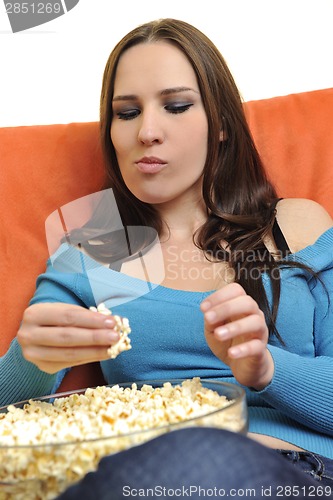 Image of young woman eat popcorn and watching tv