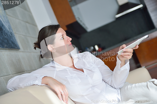 Image of young woman watching tv at home
