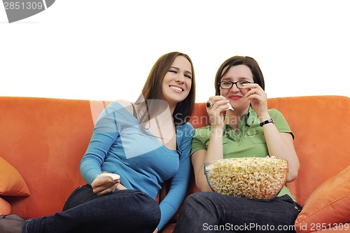 Image of female friends eating popcorn and watching tv at home