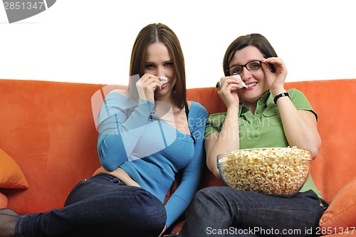 Image of female friends eating popcorn and watching tv at home