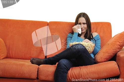 Image of young woman eat popcorn and watching tv