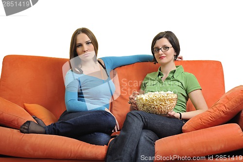 Image of female friends eating popcorn and watching tv at home